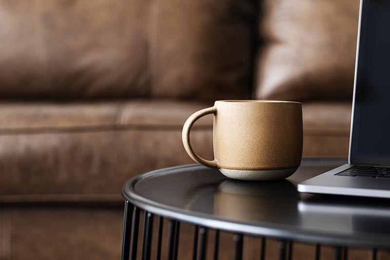 Cup of coffee by a laptop